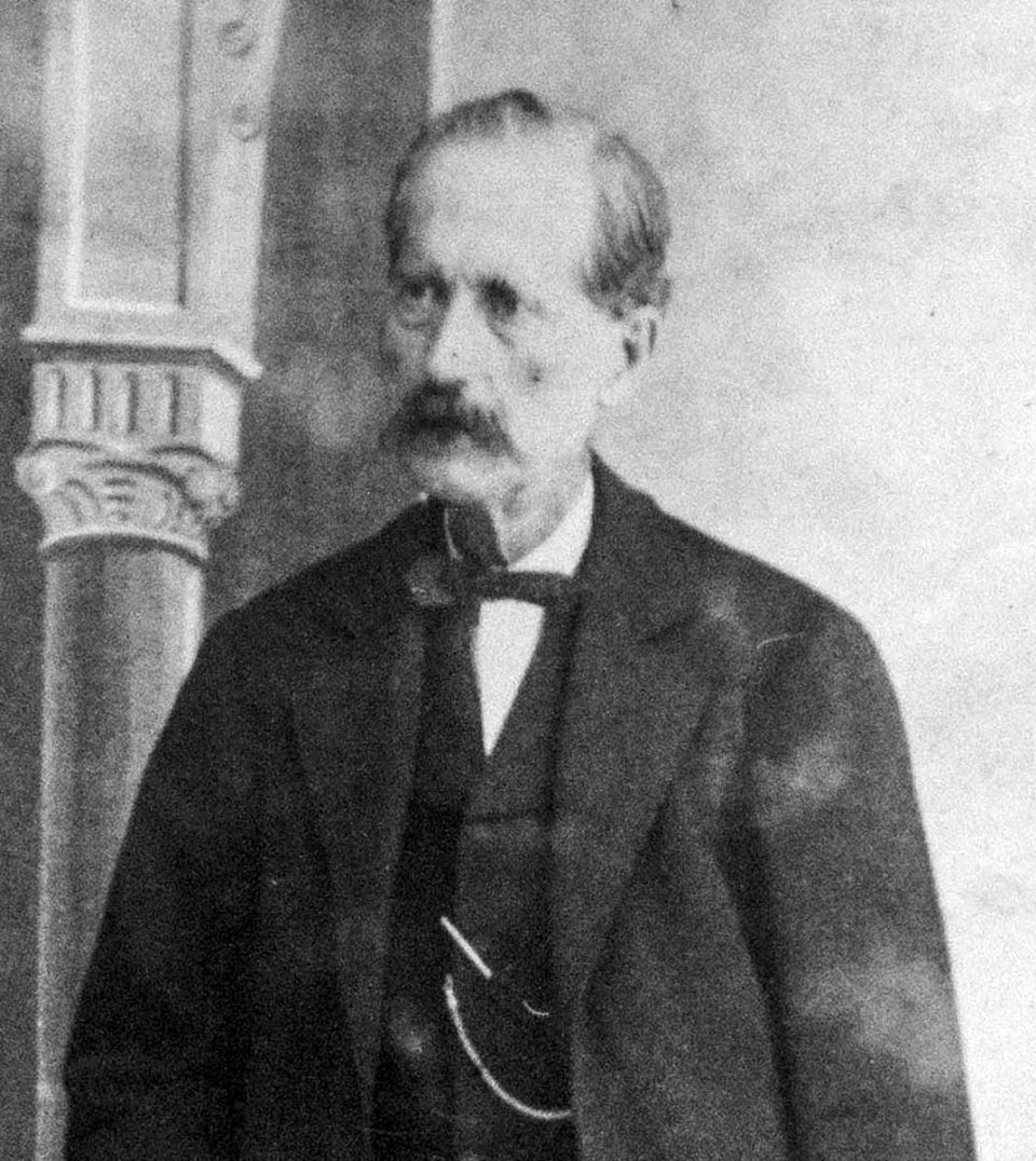 Retrato fotográfico de Antonio de Torres en su vejez, con bigote, chaqueta oscura y corbata de lazo.